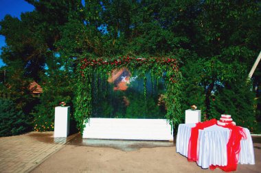 Güzel sıradışı düğün dekoru. Çiçek duvarı, fotoğraf alanında fenerler..