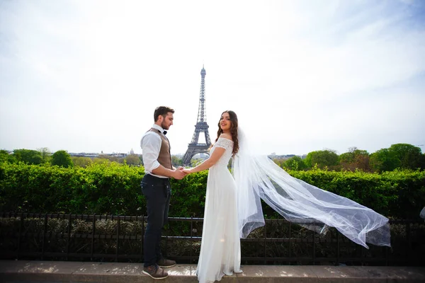 Braut und Bräutigam bei einem romantischen Moment am Hochzeitstag in Paris, vor der Eiffeltour — Stockfoto