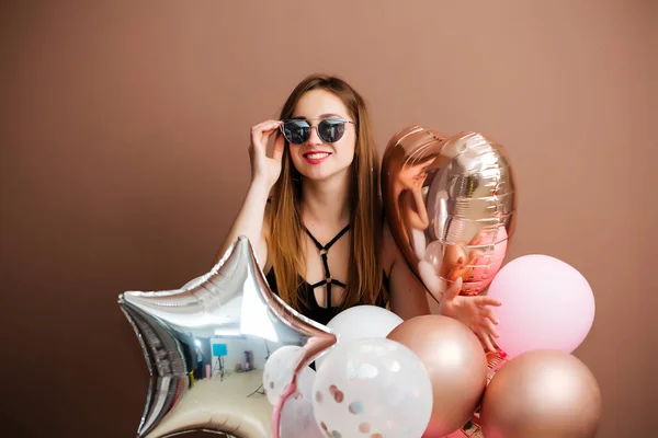 Uśmiechnięta szczęśliwa brunetka modna kobieta trzyma balony pozowanie. Zdjęcia studyjne. — Zdjęcie stockowe
