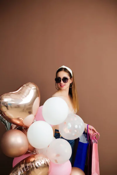 Studio portret van een jonge vrouw met een ballon in een sterhart. close-up, geïsoleerde achtergrond, kopieerruimte. — Stockfoto