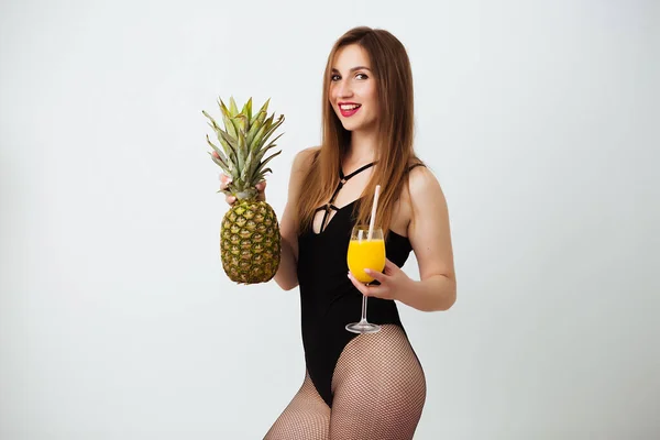 穿着泳衣的黑发女孩，背景是白色的，手里拿着鸡尾酒和菠萝 — 图库照片