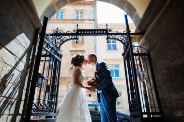 Şık gelin ve damat düğün günü dışarıda birlikte poz veriyorlar.