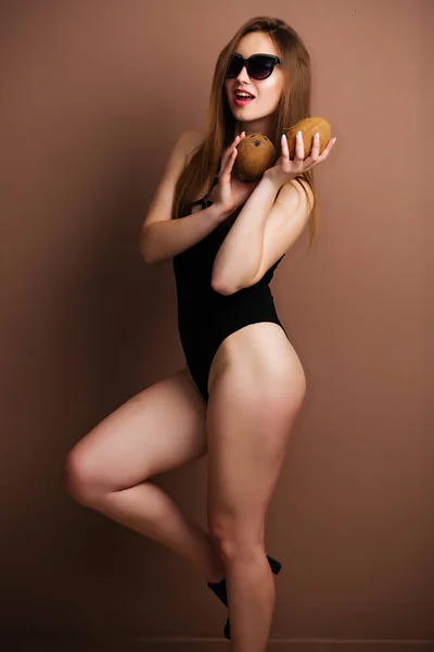 Vacker ung sexig brunett med ett leende klädd i en avslappnad sommar strand baddräkt — Stockfoto