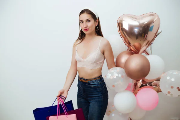 Портрет красивой женщины, покрывающей тело красочными воздушными шарами и пакетами — стоковое фото