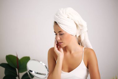 Güzel bir kadın kozmetik krem sürüyor, güzellik ve sağlık