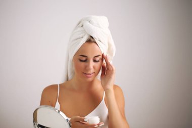 Bornozlu genç kadın, banyoya güzellik getiriyor.