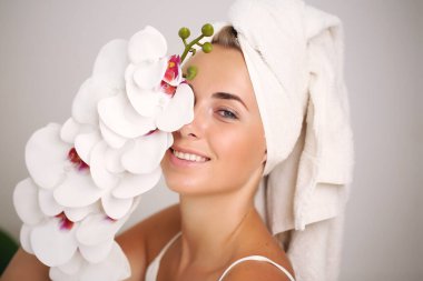 Bornozlu genç kadın, banyoya güzellik getiriyor.