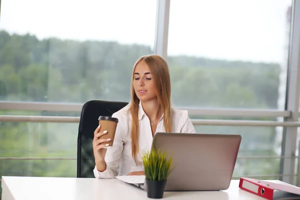 Gerente no escritório, sentado loira em uma camisa branca — Fotografia de Stock