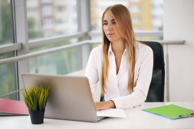 Sarışın bilgisayar üzerinde çalışıyor, iş kadını ofiste.