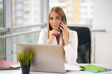 Ofis müdürü, beyaz gömlekli sarışın.