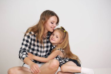 Sevgi dolu bir aile. Anne ve kızı oynuyor, öpüşüyor ve sarılıyorlar..