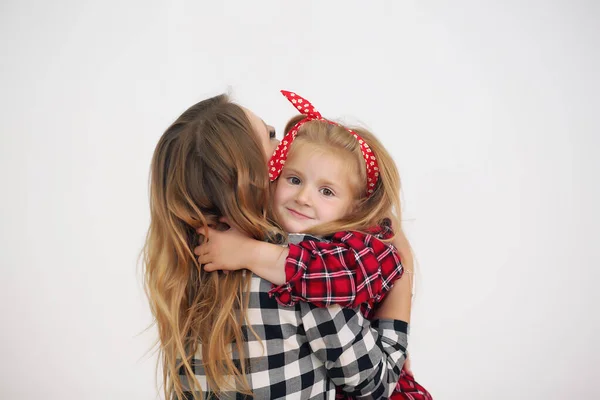 Alegre sonriente feliz mamá y su pequeña hija curiosa acostada en la cama —  Fotos de Stock