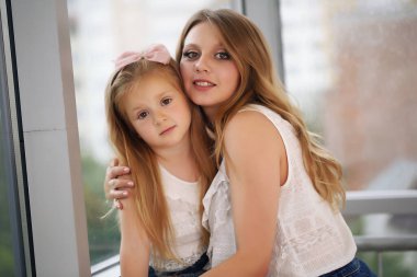 Sevgi dolu bir aile. Anne ve kızı oynuyor, öpüşüyor ve sarılıyorlar..