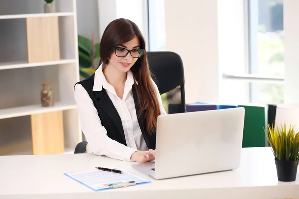 Jente som jobber hjemme med laptop og smiler, brunette i jakke – stockfoto