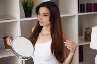 Güzellik, cilt bakımı ve insan konsepti. Gülümseyen genç kız, odadaki yüz için güzellik öneriyor.