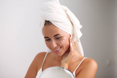 Beyaz bir arka planda izole edilmiş güzel bir spa kızı. Temiz ciltli, banyodan sonra mutlu bir kadın