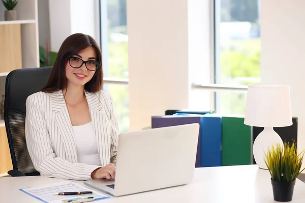 Jovem mulher de negócios trabalhando em seu escritório usando um laptop — Fotografia de Stock