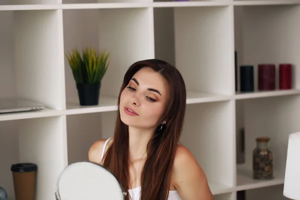 Schöne Frau, die zu Hause vor dem Spiegel glatte Haut berührt — Stockfoto