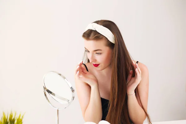 Лицо девушки перед зеркалом, у брюнетки обруч — стоковое фото