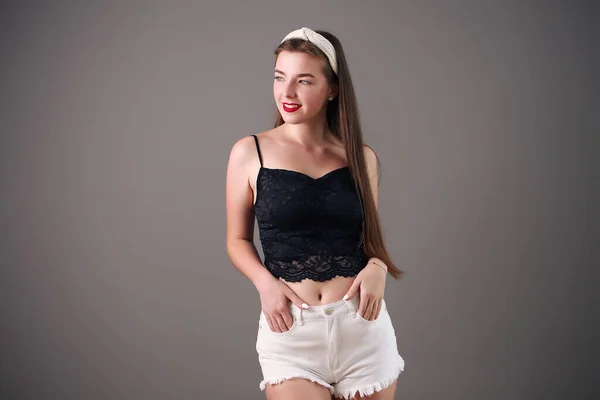 Mooi meisje in shorts en top poseren in studio — Stockfoto