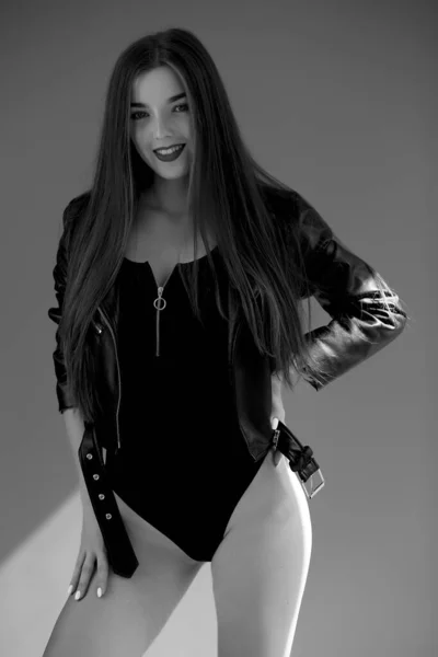 Žena v černém obleku. dívka s vlnitými vlasy. smyslný nádherný mladý dáma v černý bodysuit pózování ve studiu — Stock fotografie