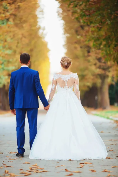 Couple de mariage, mariée en robe de mariée blanche et marié marchant dans les bois, dansant et souriant — Photo