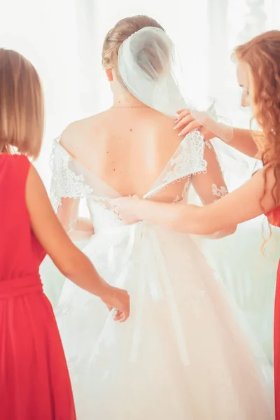 Chica en un vestido blanco en casa. Novia con maquillaje. Boda. Preparación de la novia para la próxima boda . — Foto de Stock
