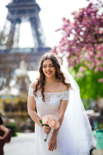 Piękna panna młoda w bogatej sukni ślubnej wiruje na placu przed Wieżą Eiffla — Zdjęcie stockowe