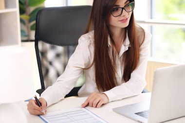 Masada çalışan takım elbiseli Avrupalı esmer, davaları çözüyor.