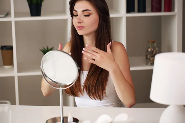 Wajah muda wanita cantik yang sehat melihat di cermin — Stok Foto