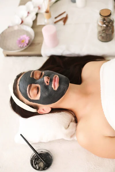 Wanita cantik muda dengan masker wajah, perawatan spa — Stok Foto