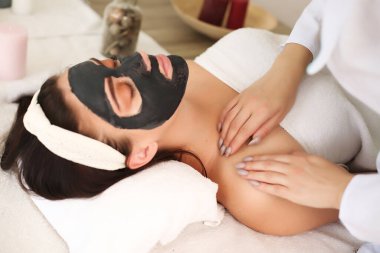 Yüz maskeli güzel bir kadın, spa tedavisi.