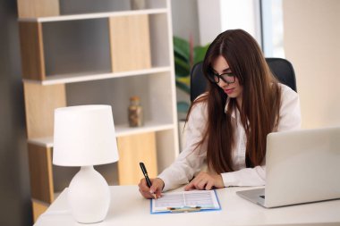 Masada çalışan takım elbiseli Avrupalı esmer, davaları çözüyor.