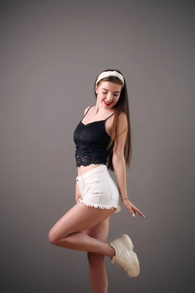 Överraskad brunett ung kvinna i denim shorts, studio — Stockfoto