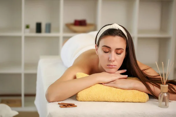 Donna rilassata sdraiata nel salone spa con gli occhi chiusi, in attesa di massaggio — Foto Stock