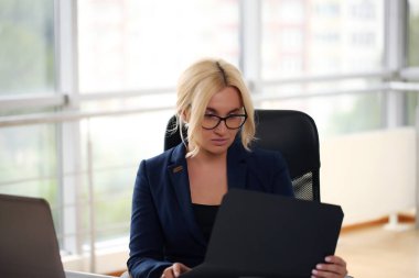 Başarılı bir iş adamı elinde satış dosyalarıyla gülümserken. iş kadını