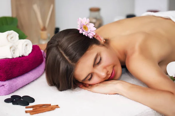 Schoonheid en spa concept - gelukkig vrouw in spa salon liggend op het massagebureau — Stockfoto