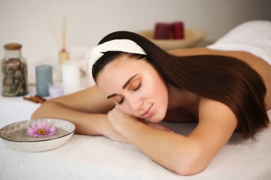 Güzel bir kadın sırt masajı yaptırıyor ve kendini iyi hissediyor.