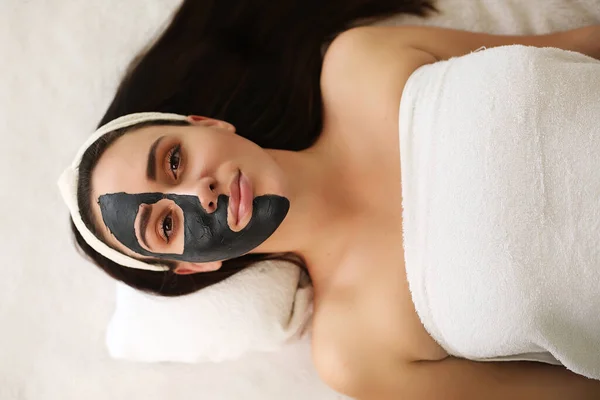 Kosmetisk maske i ansiktet, brunette som gjør behandling på spa – stockfoto