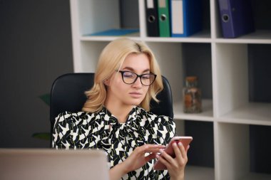 Ofisinde not defteri olan genç ve güzel bir iş kadını.