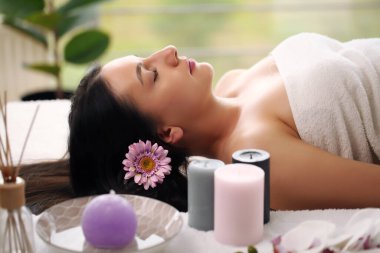 Kaplıca salonunda gözleri kapalı, masaj için bekleyen rahat bir kadın.