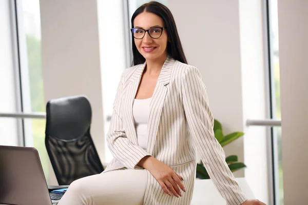 smiling business lady sitting in a suit on the table