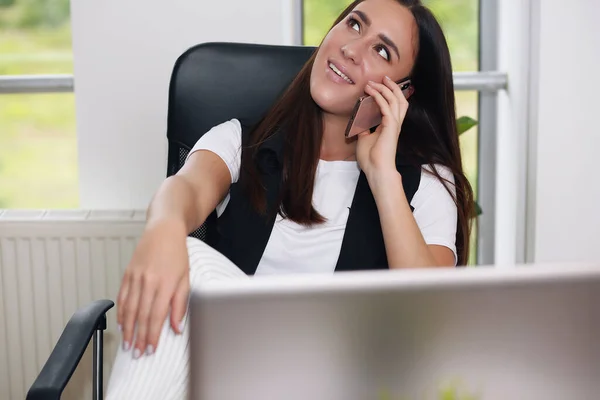 Radosna kobieta siedząca w biurze w miejscu pracy. Myśli o swoim biznesie.. — Zdjęcie stockowe