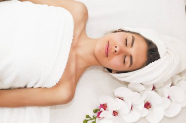 Kız kaplıcada dinleniyor, sırtında havluyla.