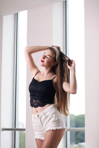 Vacker flicka i shorts och topp poserar i studio — Stockfoto