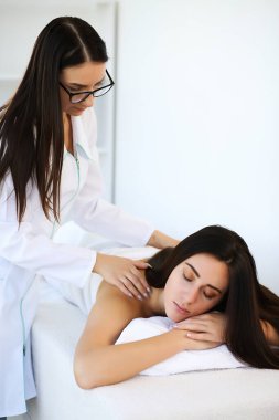 Çekici esmer, gözleri kapalı rahatlıyor ve spa tedavisinin tadını çıkarıyor..