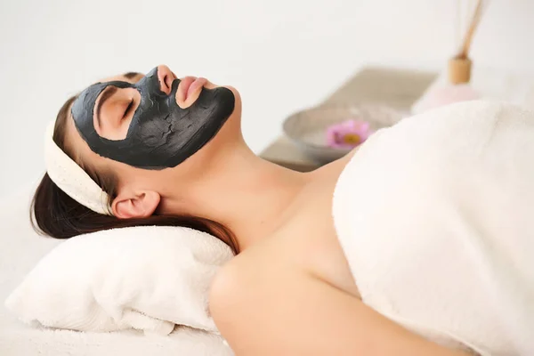 Spa. Wanita lucu yang menarik dengan masker tanah liat di wajahnya. — Stok Foto