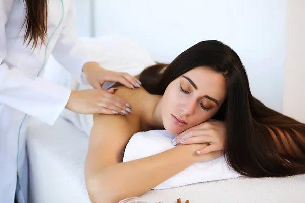 Jovem mulher bonita desfrutando de massagem na mesa no centro de spa — Fotografia de Stock