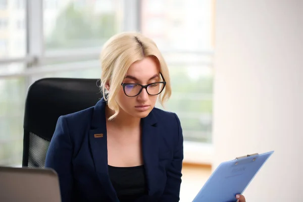 Work from home. Beautiful girl in a suit at the table,