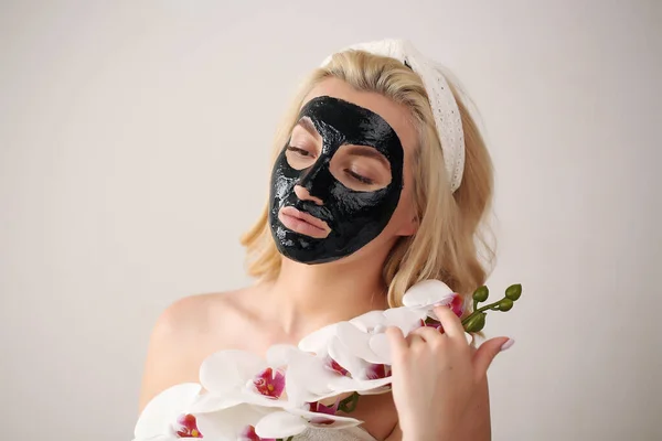 얼굴에 검은 숯 마스크를 쓴 아름다운 여성. 피부 관리, 여드름 치료, 피부 정화. — 스톡 사진